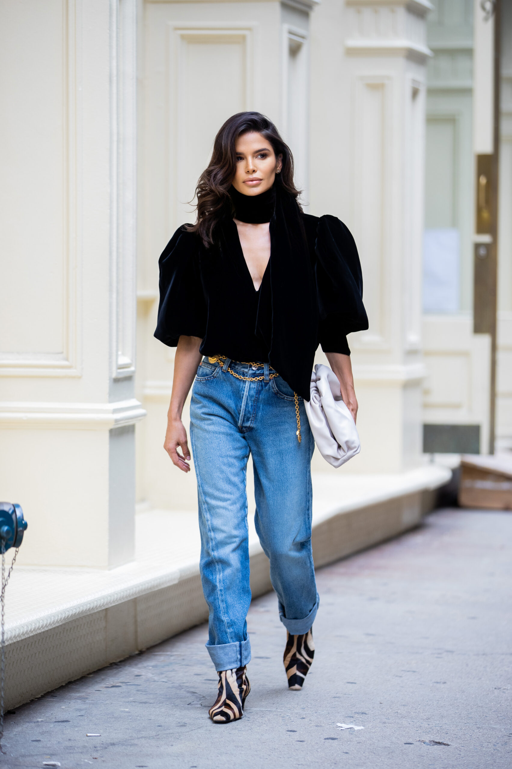 Victoria Barbara walking toward the camera during New York Fashion Week wearing Balenciaga jeans, KHAITE velvet top and Chanel chain belt.