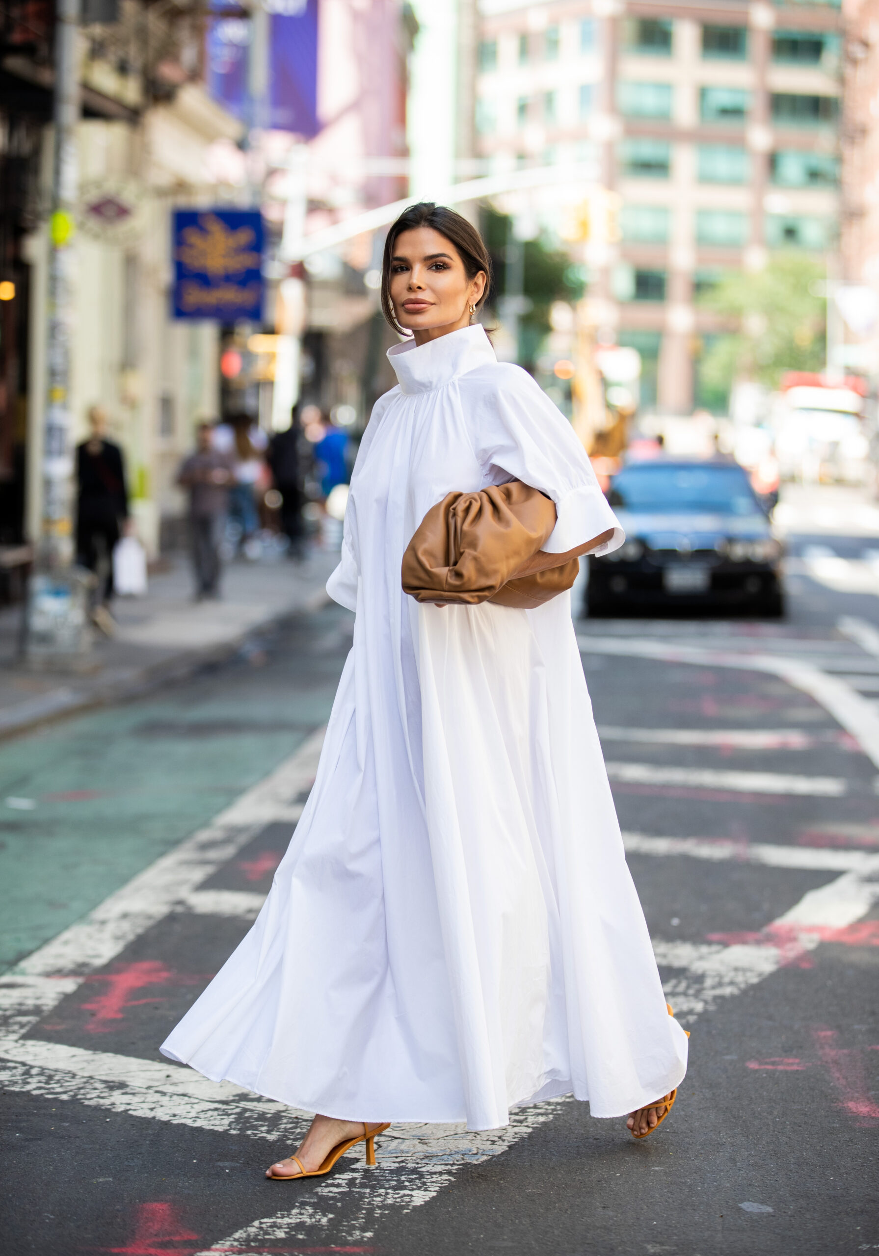 Victoria Barbara standing on a New York street in a white The Row dress paired with Bottega Veneta accessories during New York Fashion Week.