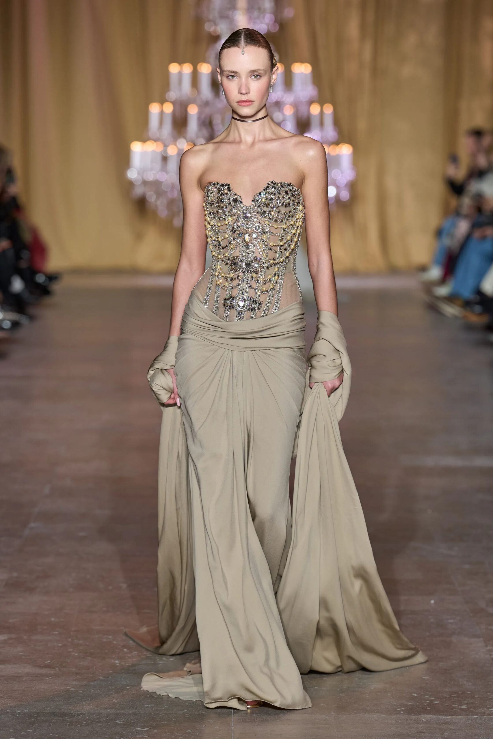 Model wearing a crystal embellished corset with flowing taupe draped fabric in Zuhair Murad Spring 2026 Couture