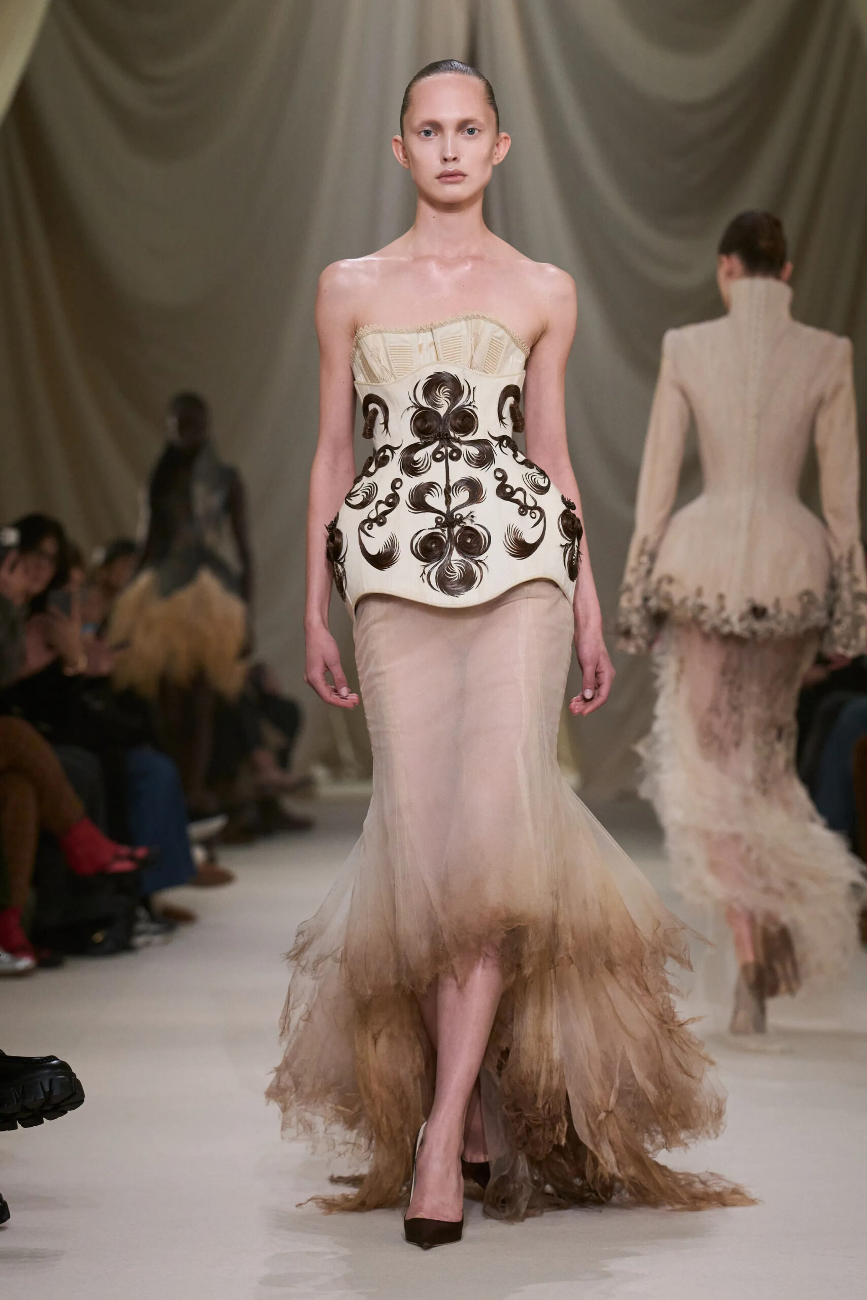 Ashi Studio Spring 2026 Couture ivory corset featuring black embroidered motifs paired with a sheer feathered skirt.