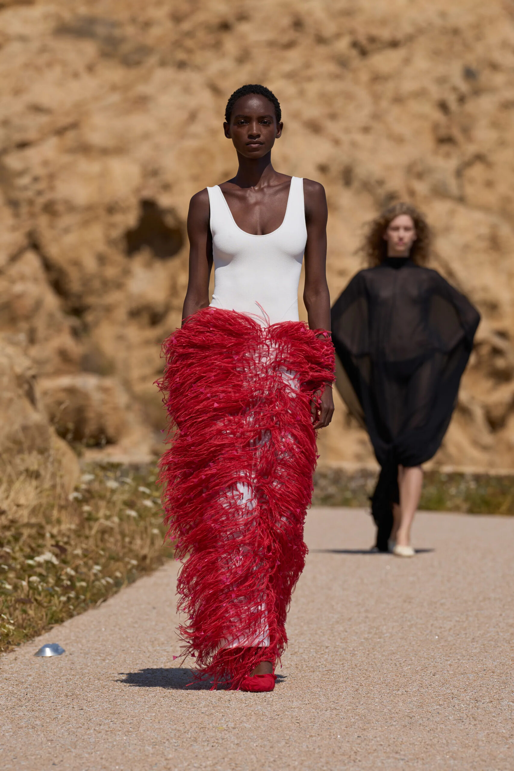 Jacquemus Spring Summer 2027 white bodysuit paired with dramatic red feather skirt.