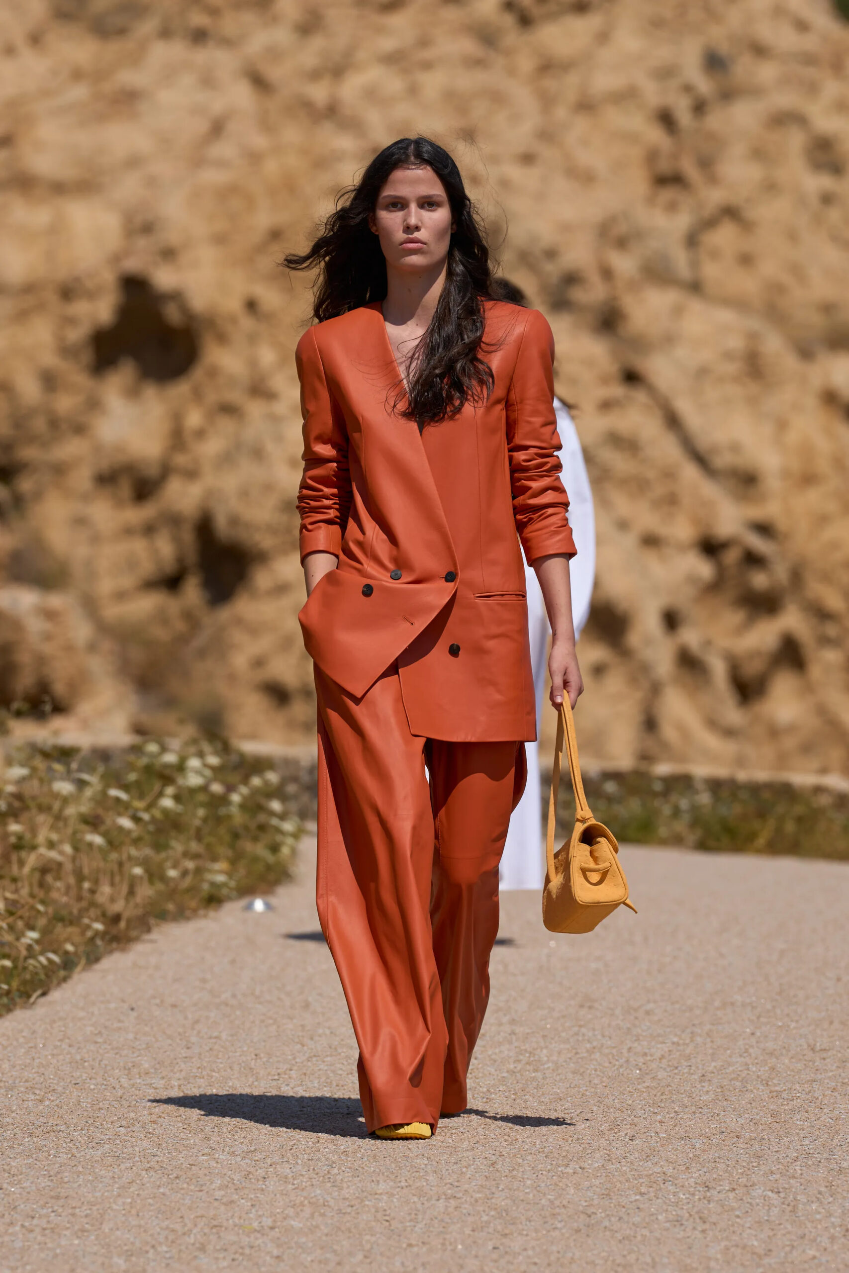 Jacquemus Spring Summer 2027 terracotta leather suit styled with mustard handbag.