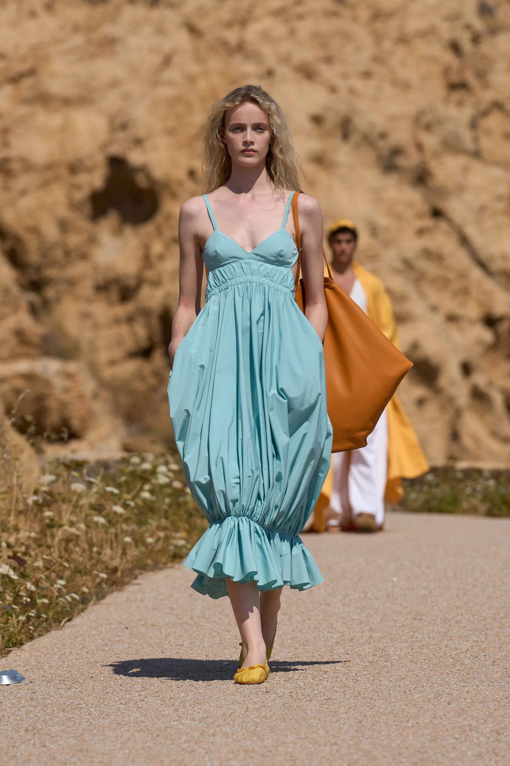 Closing look from Jacquemus Spring Summer 2027 featuring an aqua gathered dress with oversized leather tote bag.