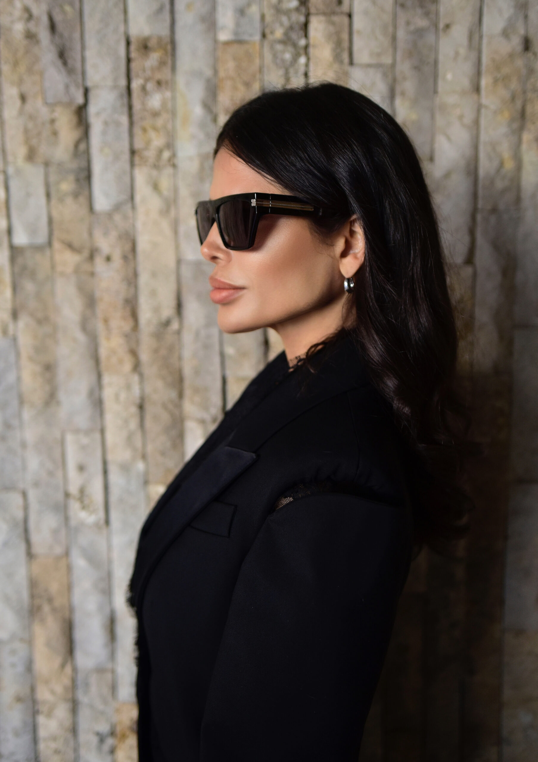 Side profile of Victoria Barbara wearing Alexander McQueen tailoring with soft lace movement and Givenchy sunglasses.
