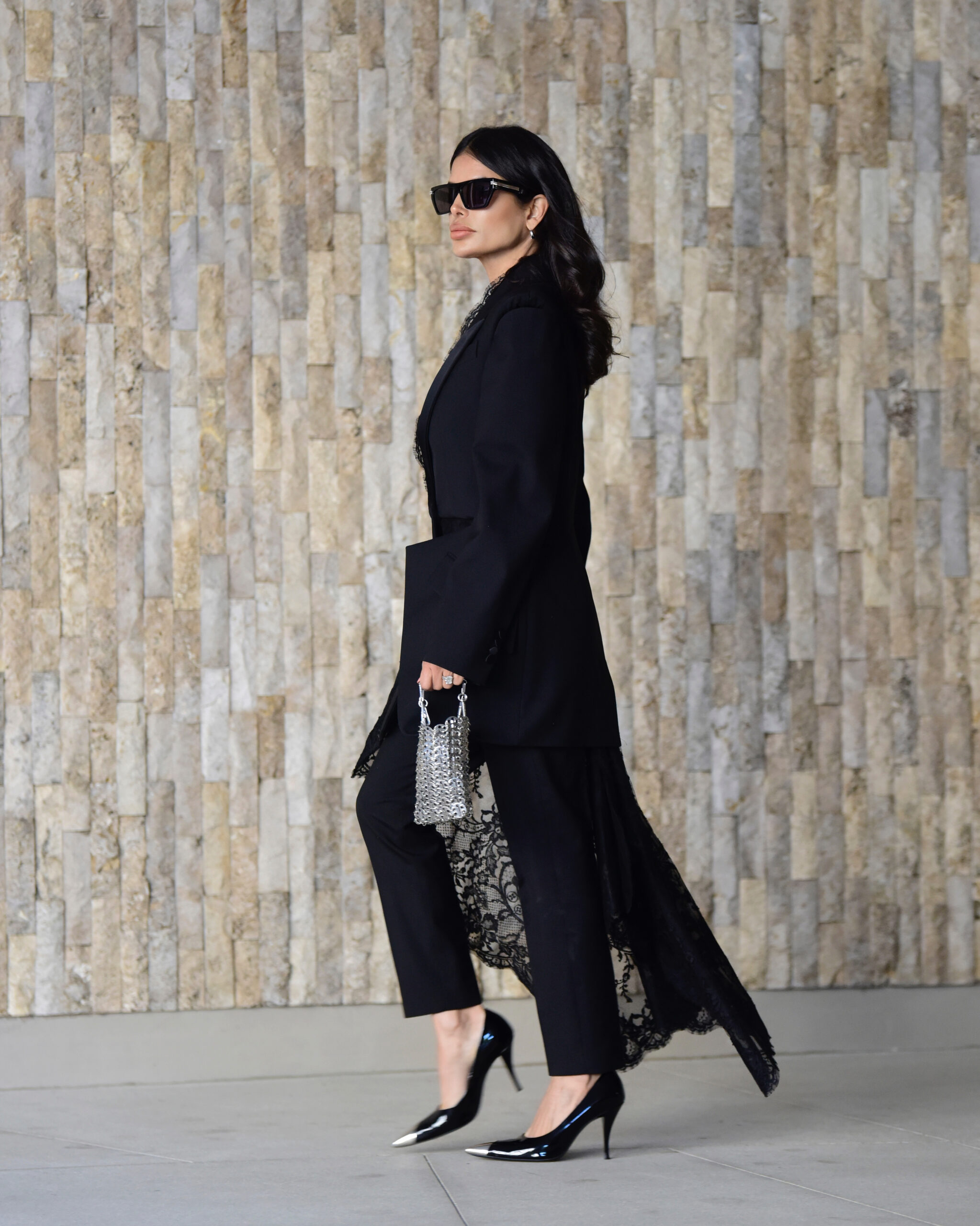 Victoria Barbara standing in an Alexander McQueen tailored look styled with a Paco Rabanne bag and Saint Laurent heels.