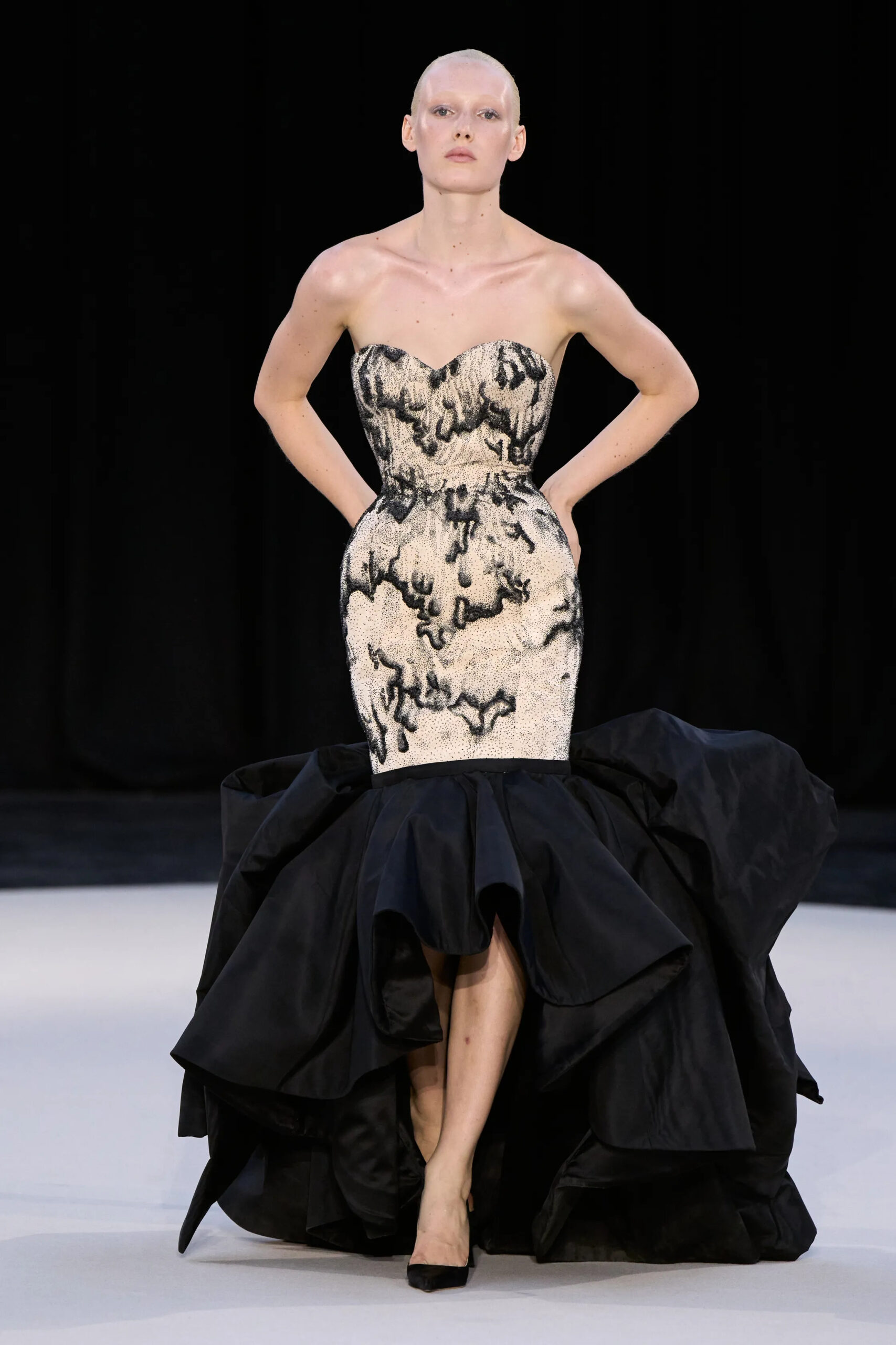 A sculpted silver corset meets a sweeping black train in one of Ashi Studio’s defining couture statements