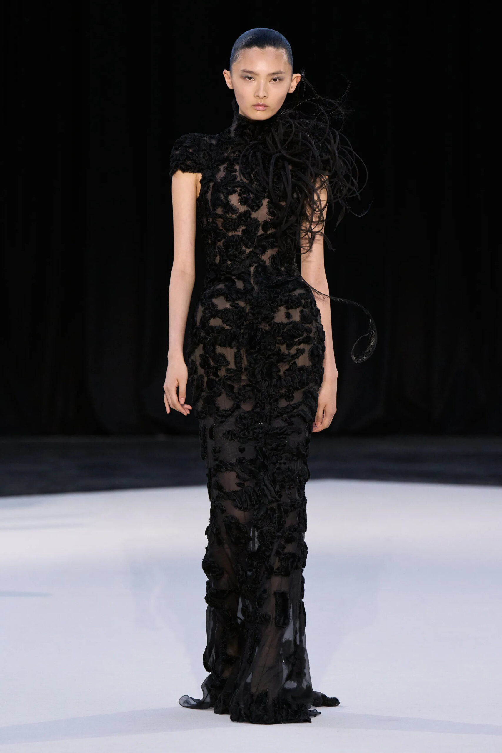 Model wearing a sheer black embroidered couture gown with sculptural feather detailing from Ashi Studio Fall 2026 Couture