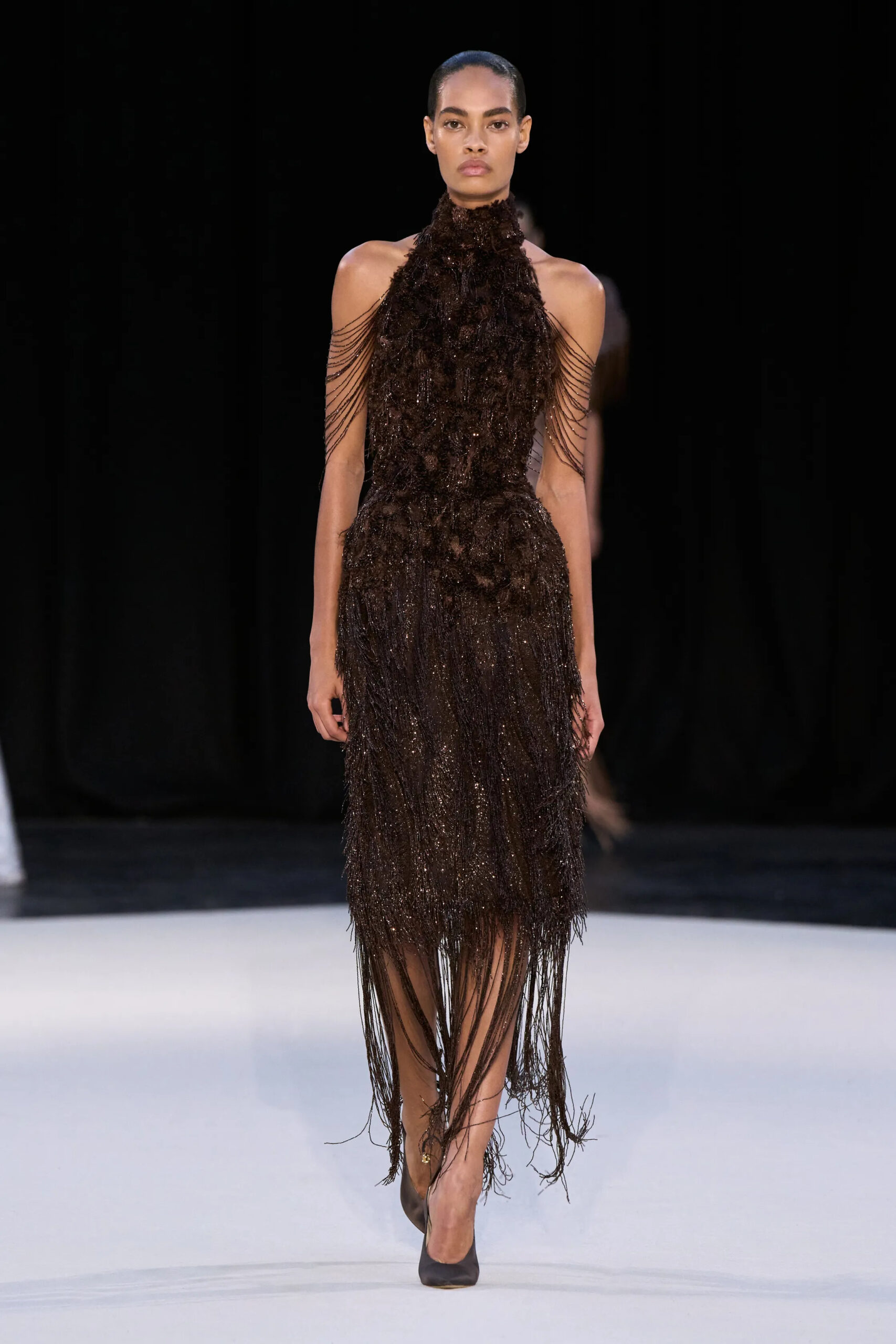 Model wearing a brown embellished halter gown with shimmering fringe from Ashi Studio Fall 2026 Couture