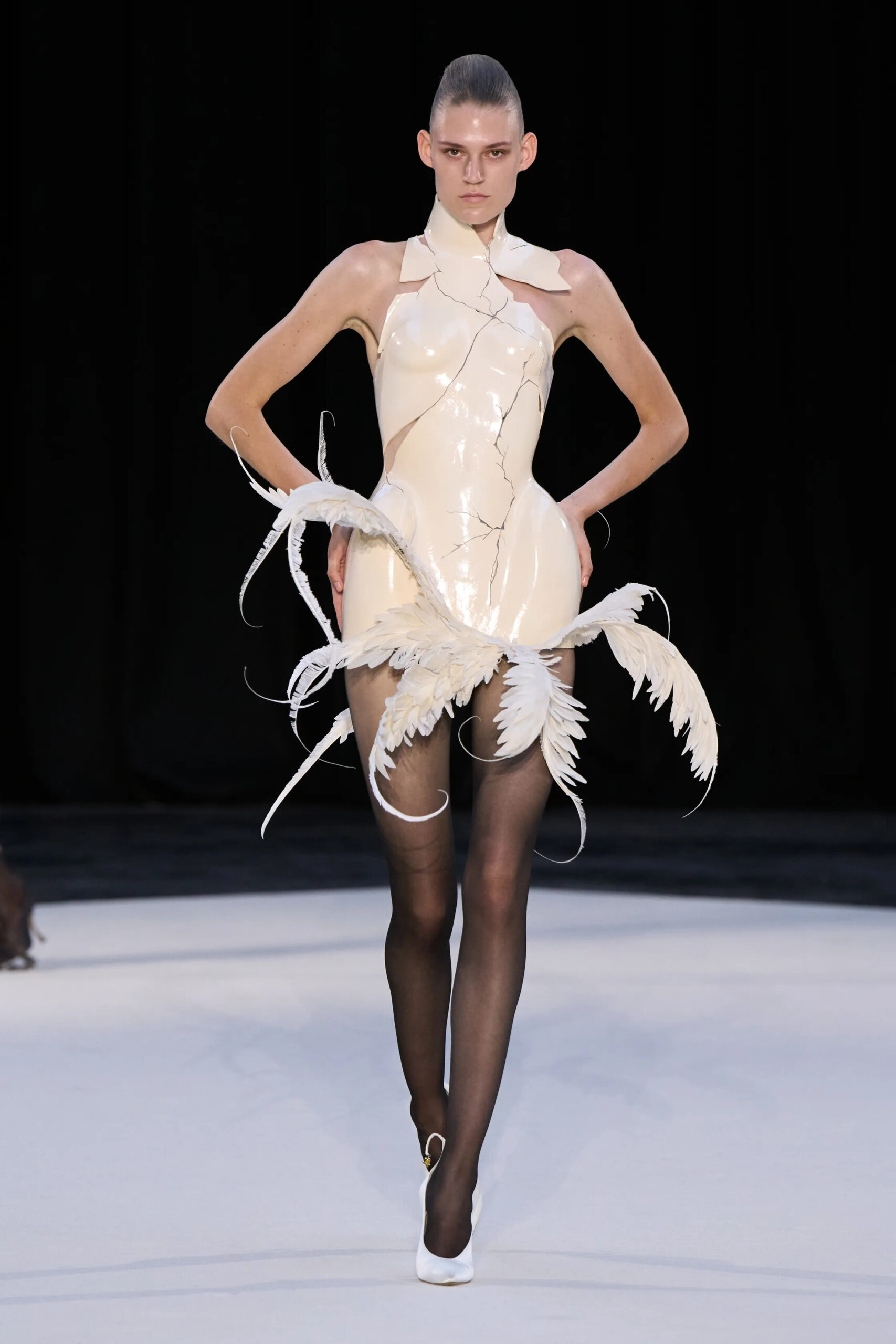 Model wearing an ivory sculptural mini dress with feather-inspired extensions from Ashi Studio Fall 2026 Couture
