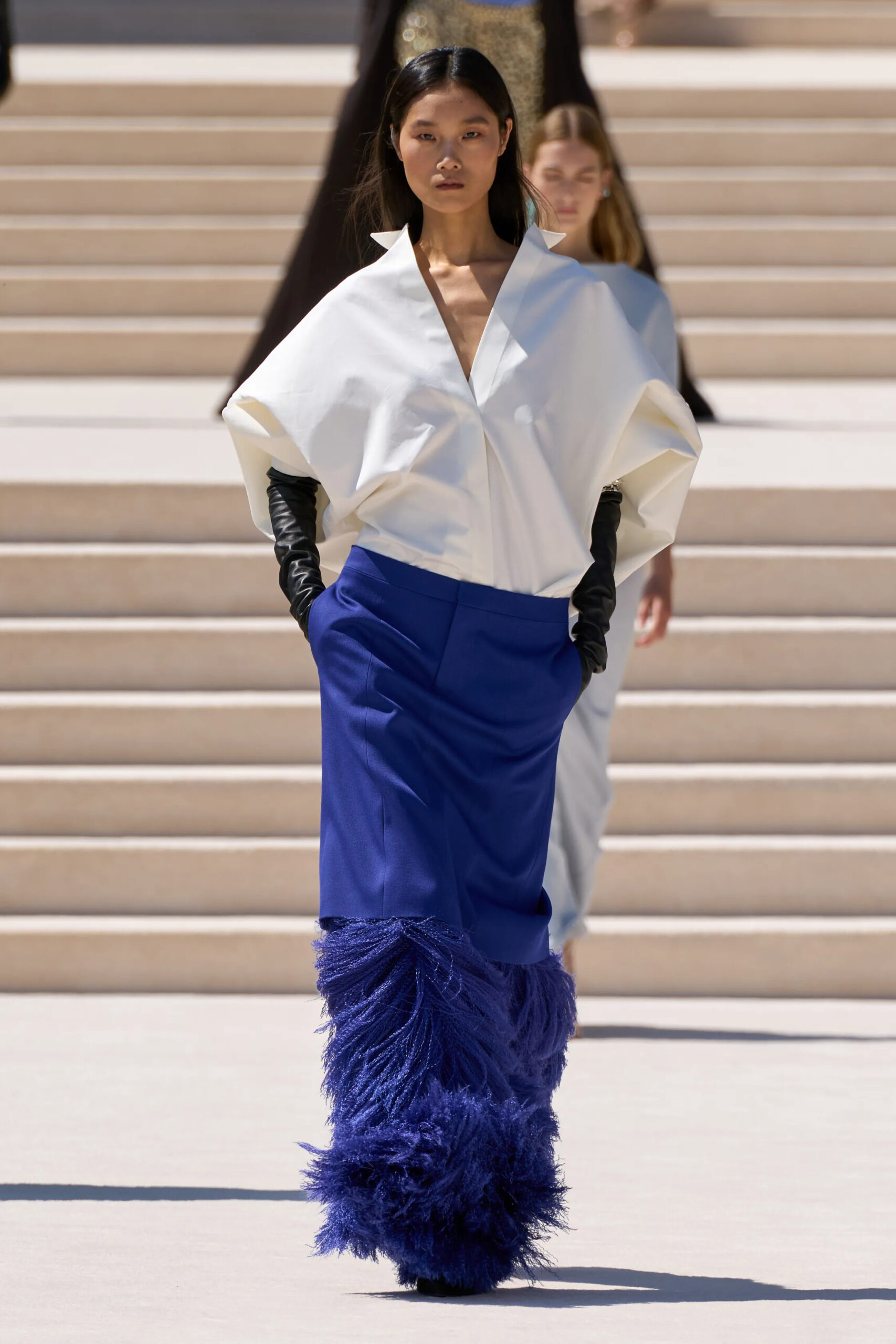 Model wearing an oversized white couture shirt paired with a cobalt feathered skirt from Balenciaga Fall 2026 Couture