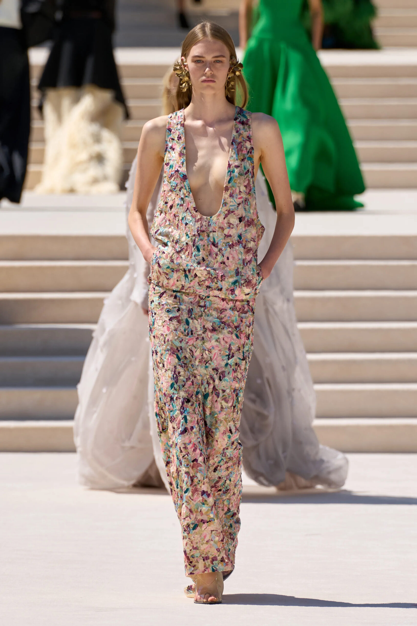 Model wearing a floral embroidered Balenciaga couture column gown with a deep neckline