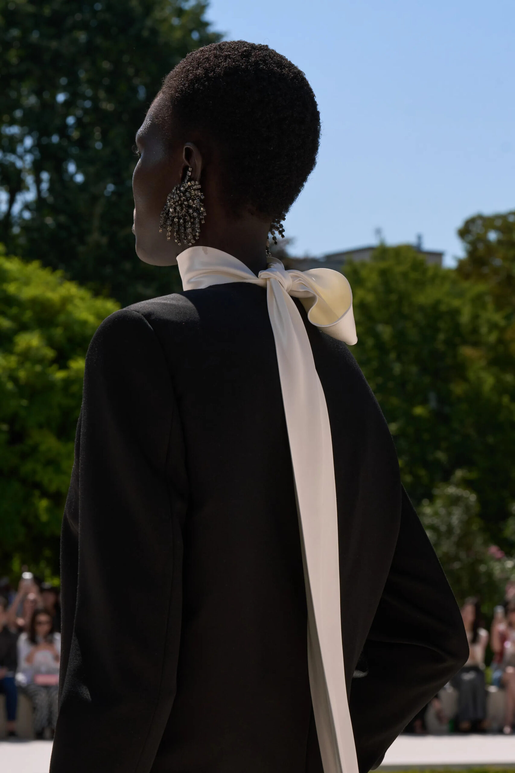 Long ivory silk bow flowing down the back of a black Balenciaga Fall 2026 Couture look