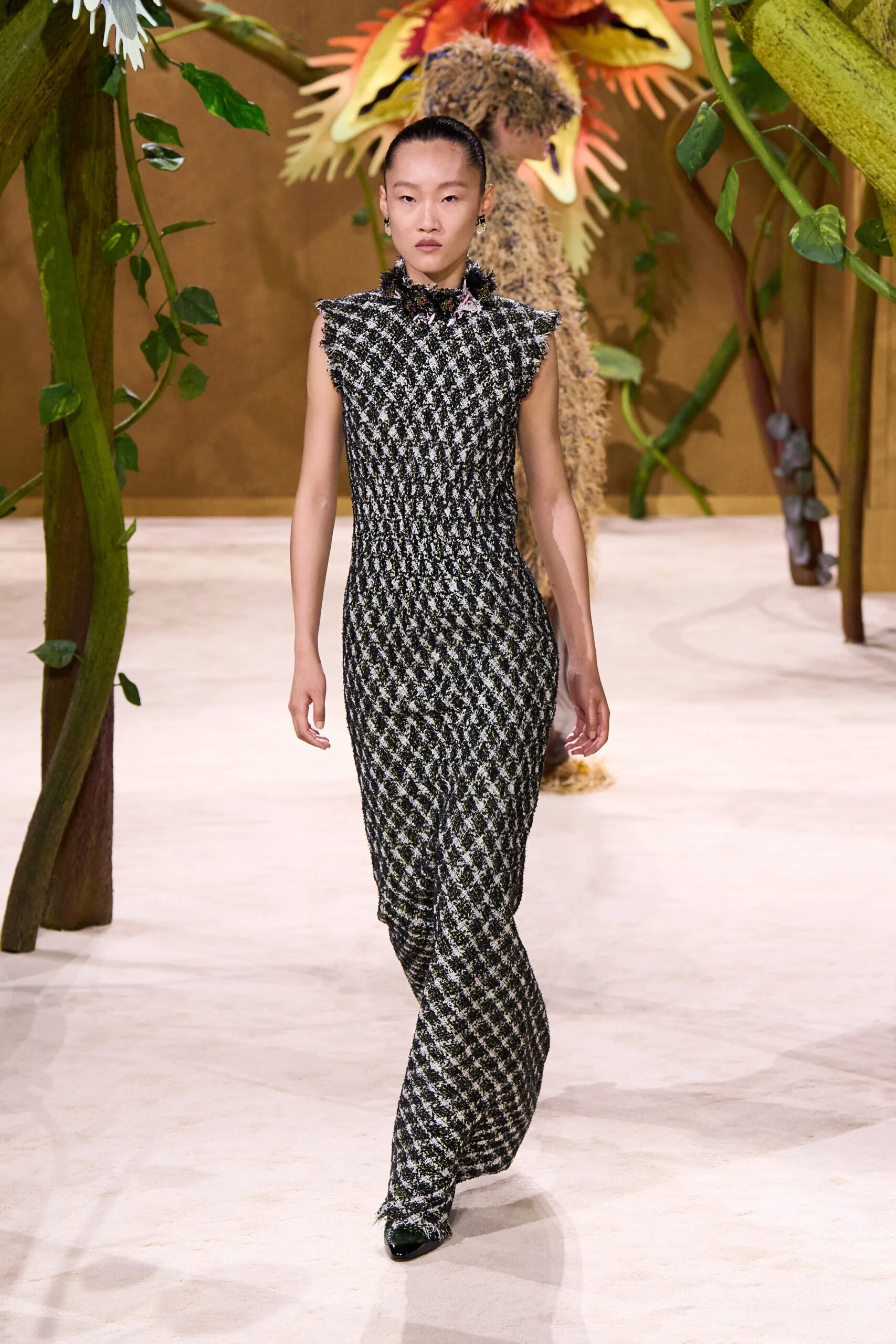 Model wearing a fitted black and ivory Chanel couture knit column dress with subtle texture