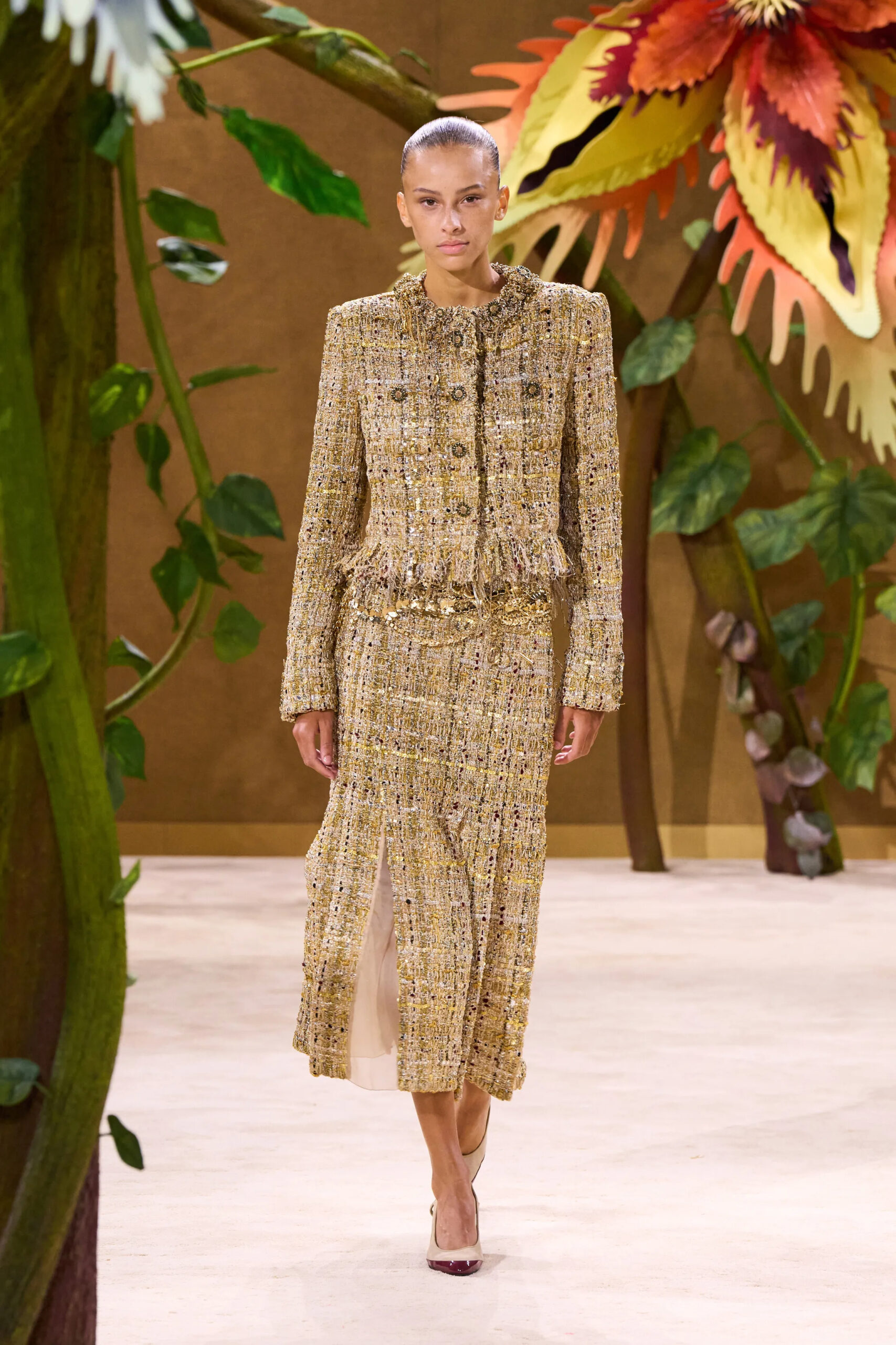 Model wearing a gold tweed Chanel Fall 2026 Couture jacket and skirt ensemble
