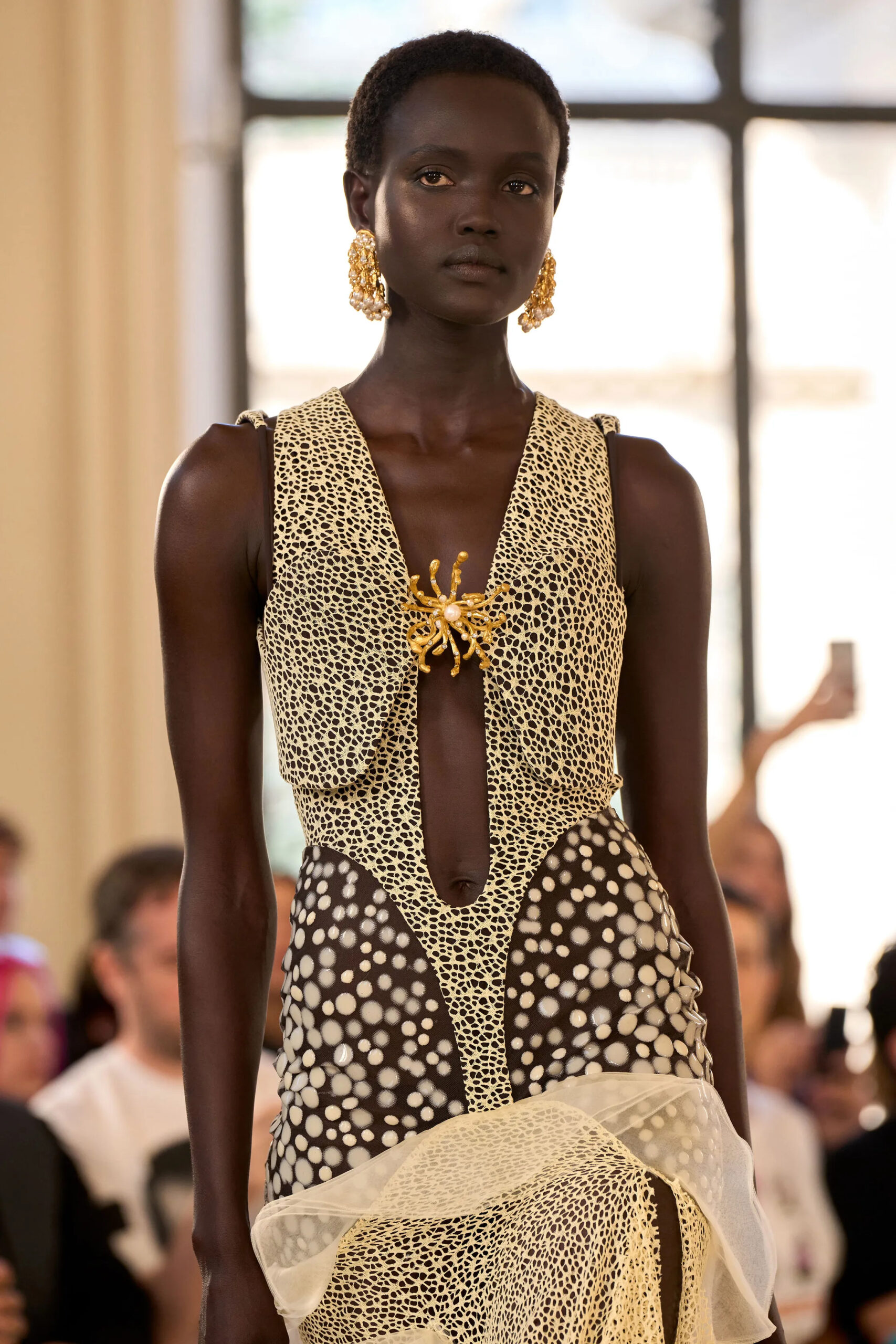 Close-up of gold spider brooch fastening a Schiaparelli Fall Winter 2026 Couture dress