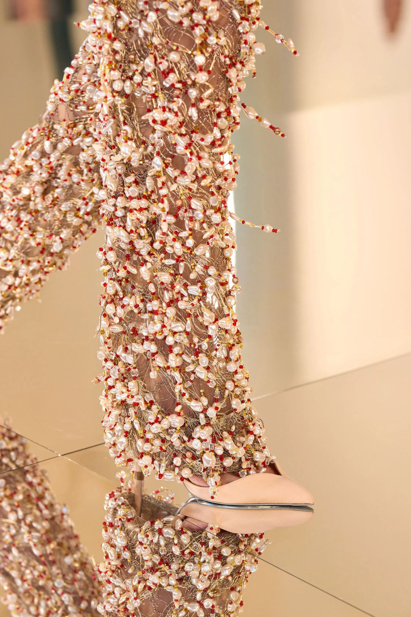 Close-up of Schiaparelli couture embroidery featuring pearls, crystals and intricate gold threadwork