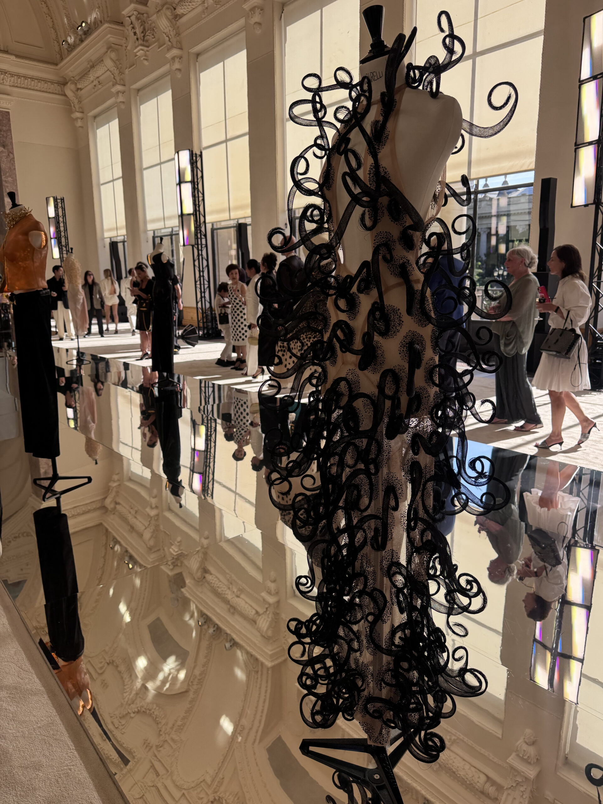 Black Schiaparelli couture gown with dramatic sculptural scrollwork at the private presentation inside the Petit Palais