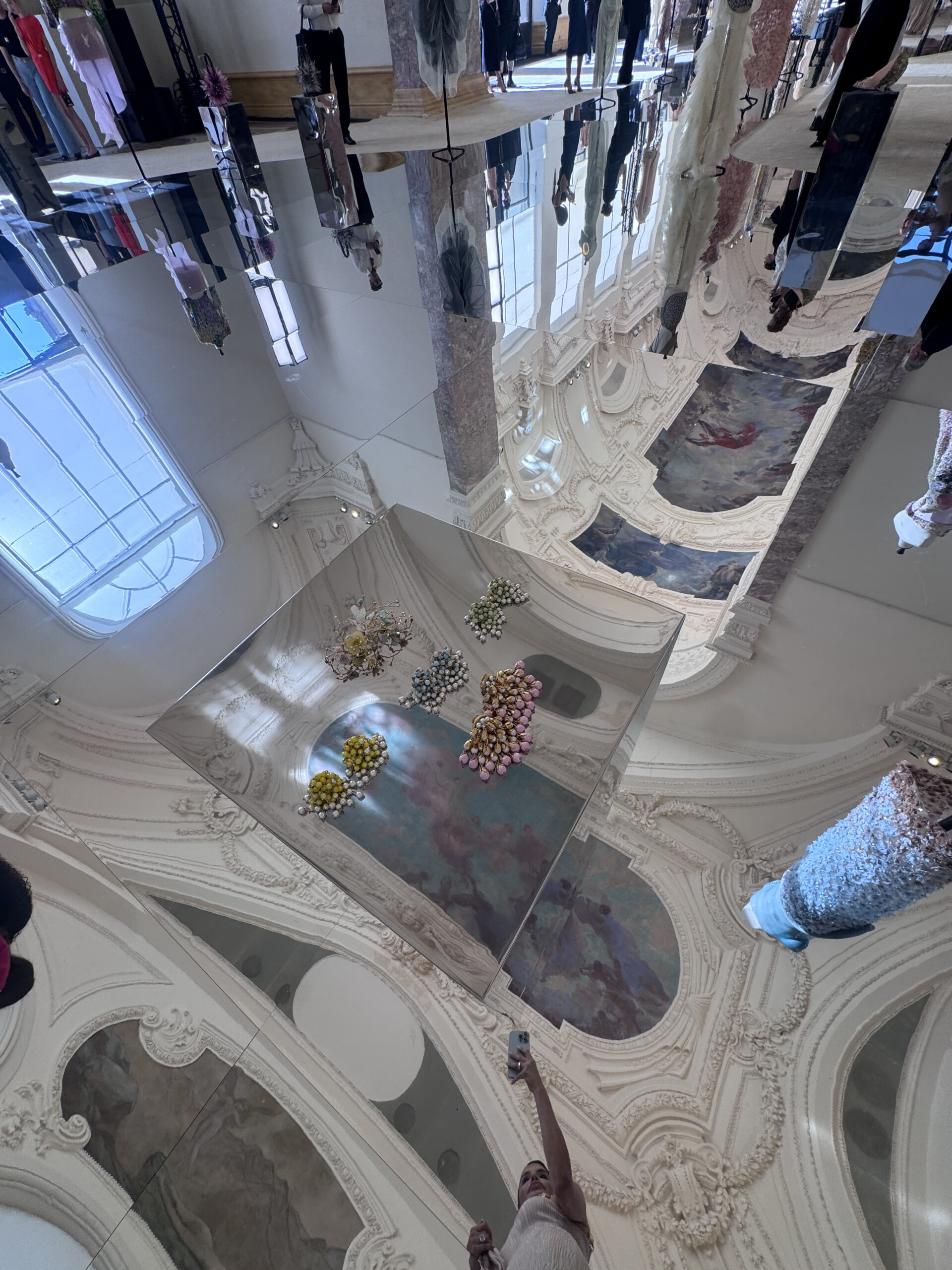 Schiaparelli couture jewelry displayed beneath the mirrored installation at the private presentation inside the Petit Palais