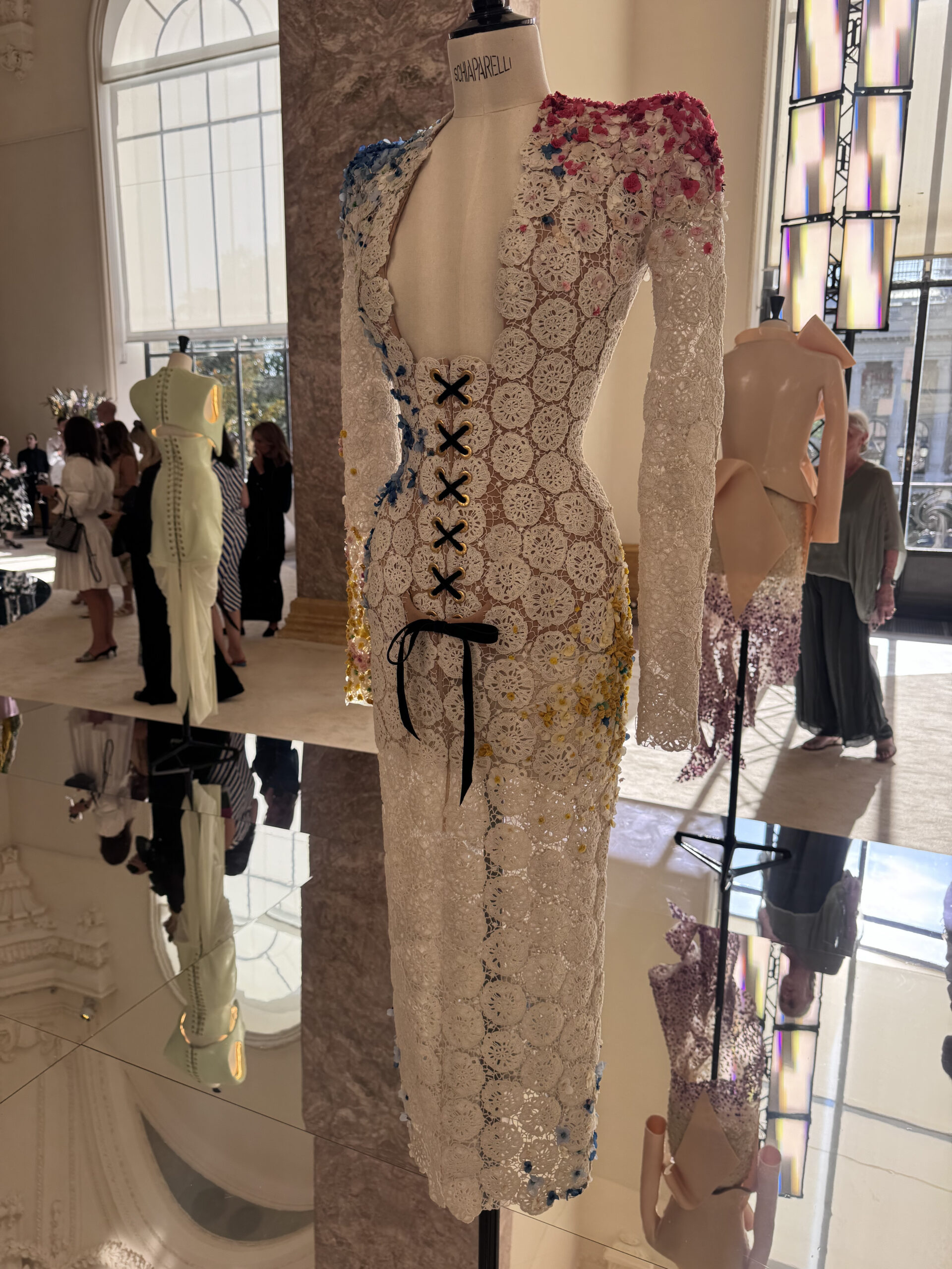 White lace Schiaparelli couture dress with contrasting black lacing displayed during the Fall Winter 2026–2027 presentation