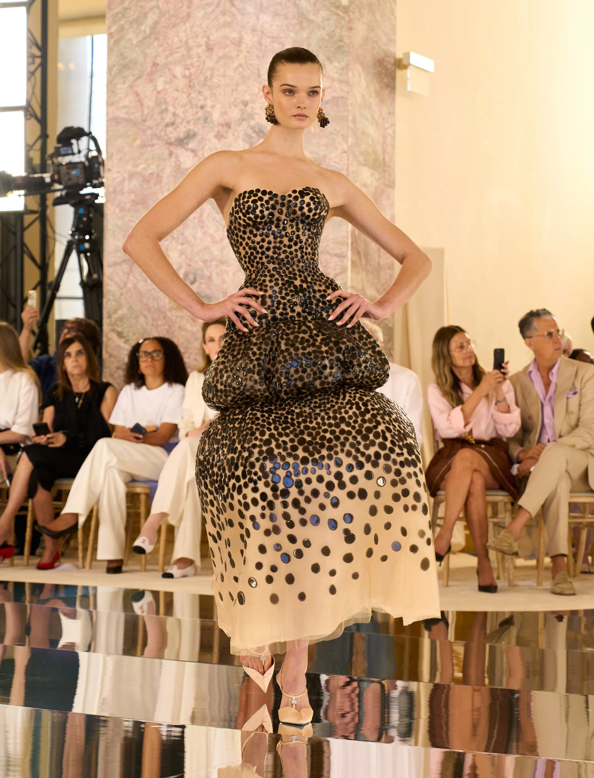 Sculptural Schiaparelli couture dress featuring oversized rounded hips and glossy embellishment.