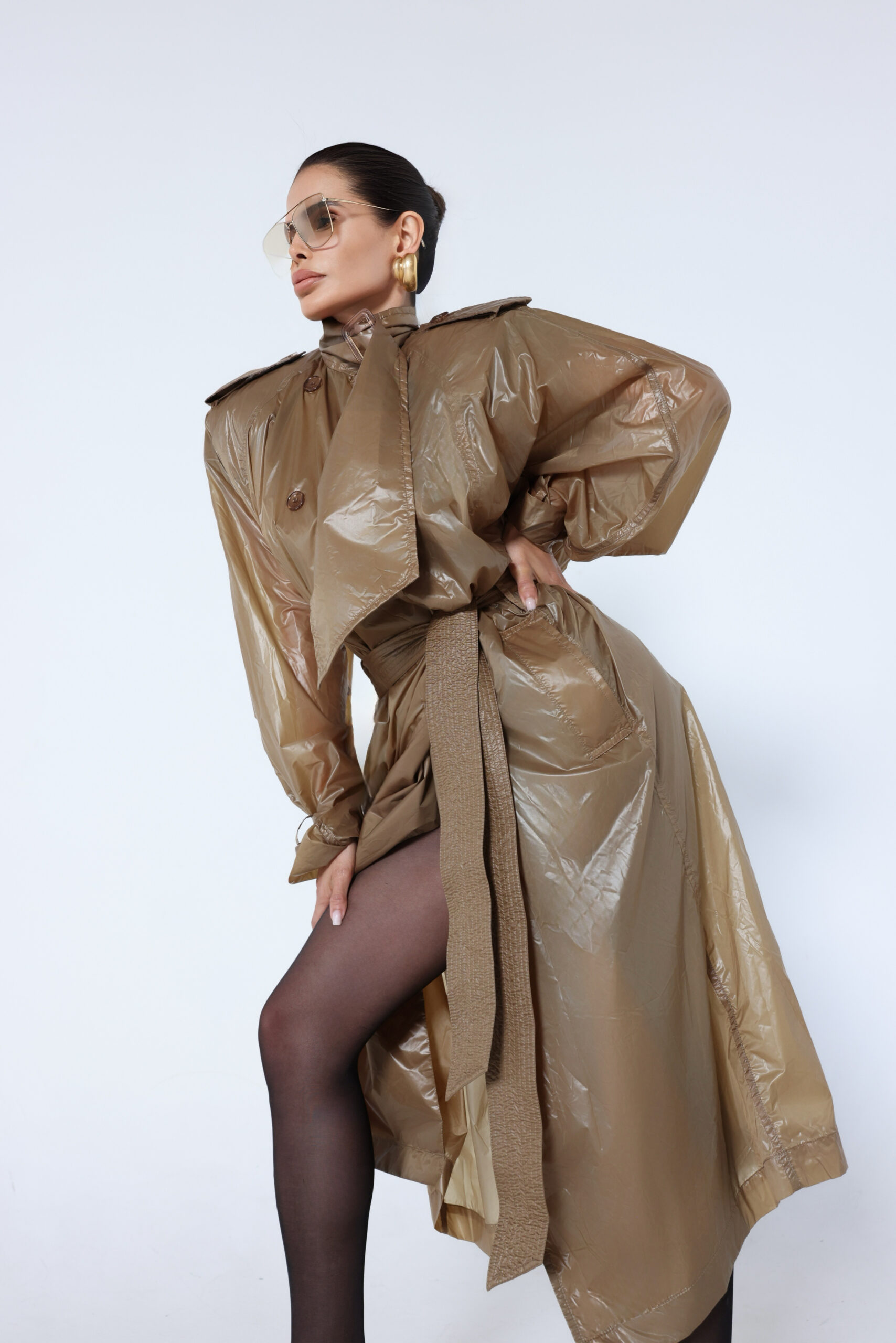 Victoria Barbara wearing Saint Laurent in a modern editorial featuring an oversized trench silhouette, gold earrings, and architectural composition